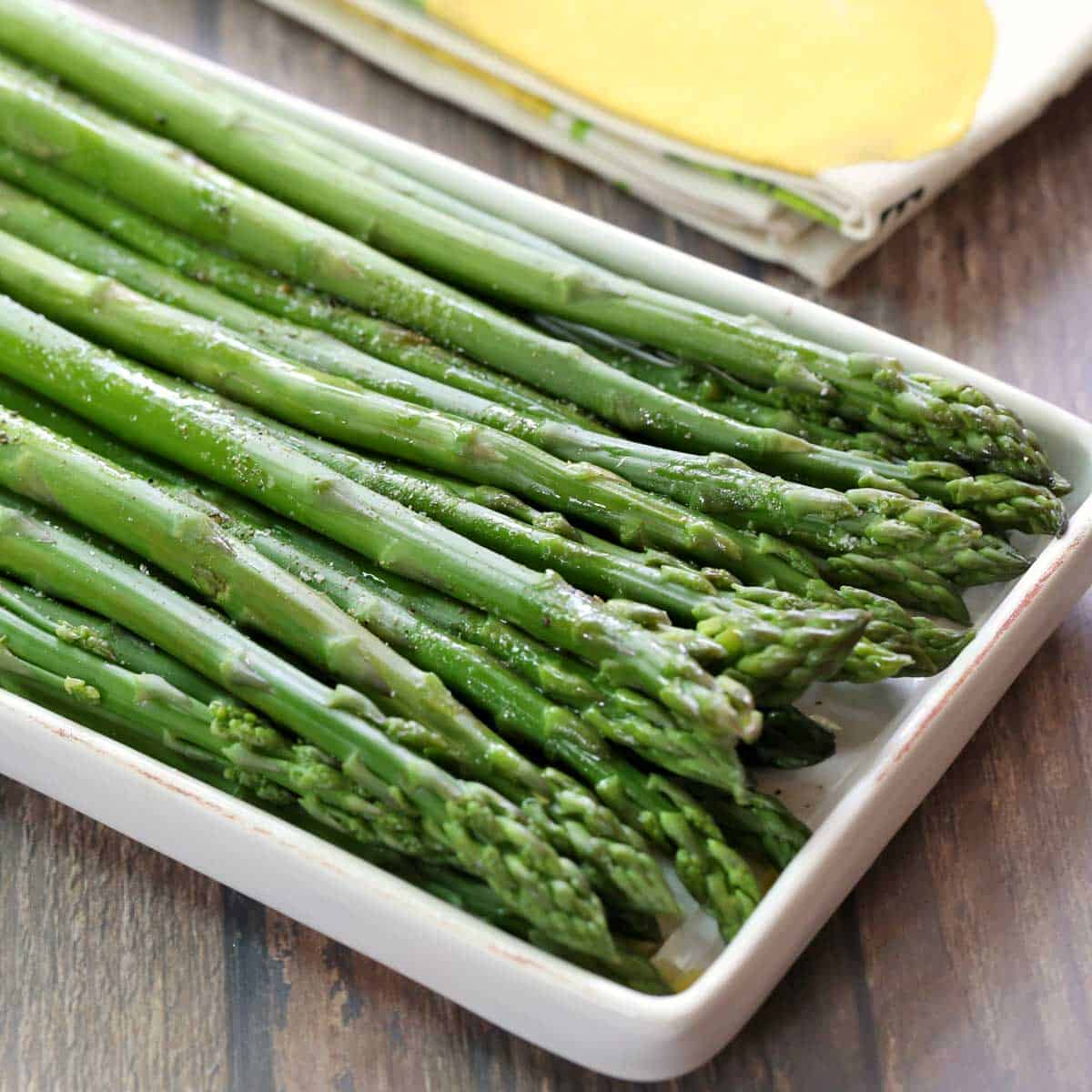 Steamed asparagus is served on a serving platter.