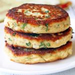 Leftover turkey patties are stacked on a white plate.