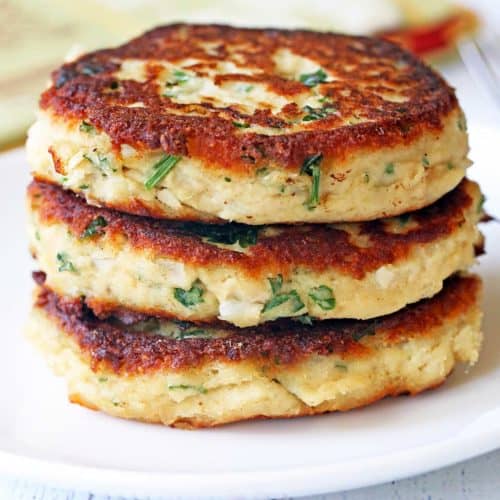 Leftover turkey patties are stacked on a white plate.