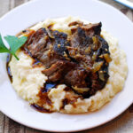 Keto pot roast is served on top of mashed cauliflower.