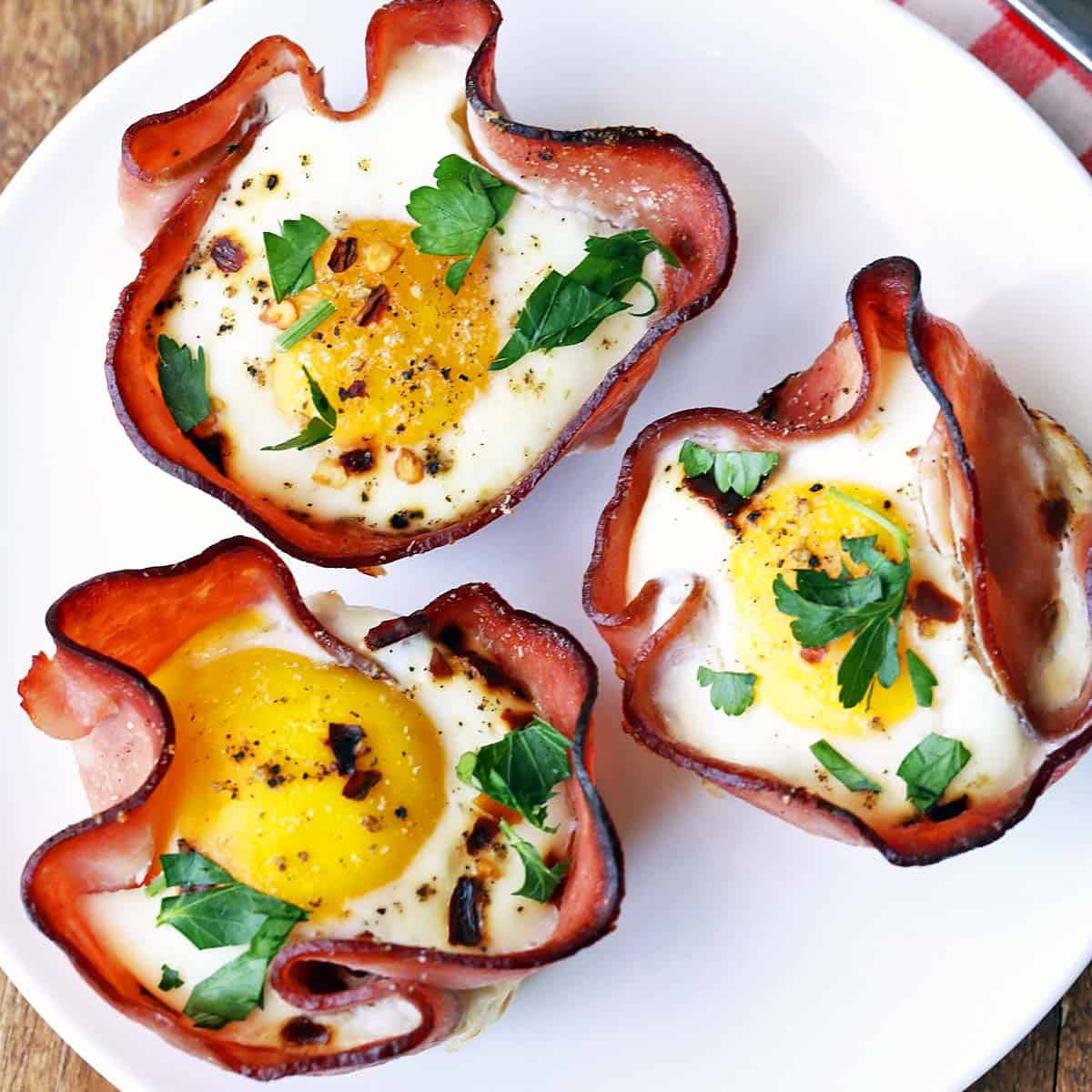 Ham and egg cups are served on a white plate.