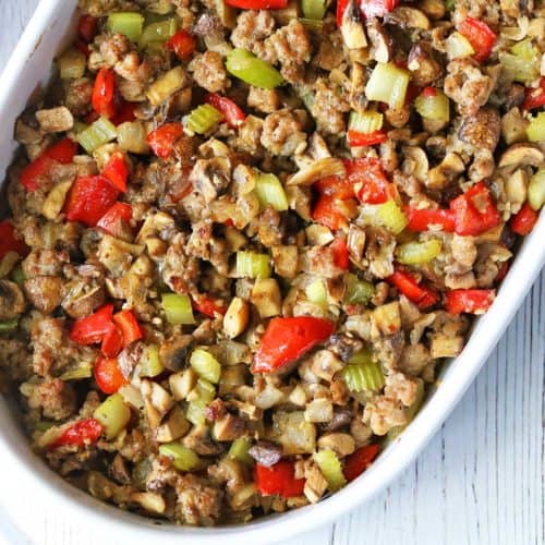 Sausage stuffing is served in a white oval baking dish.