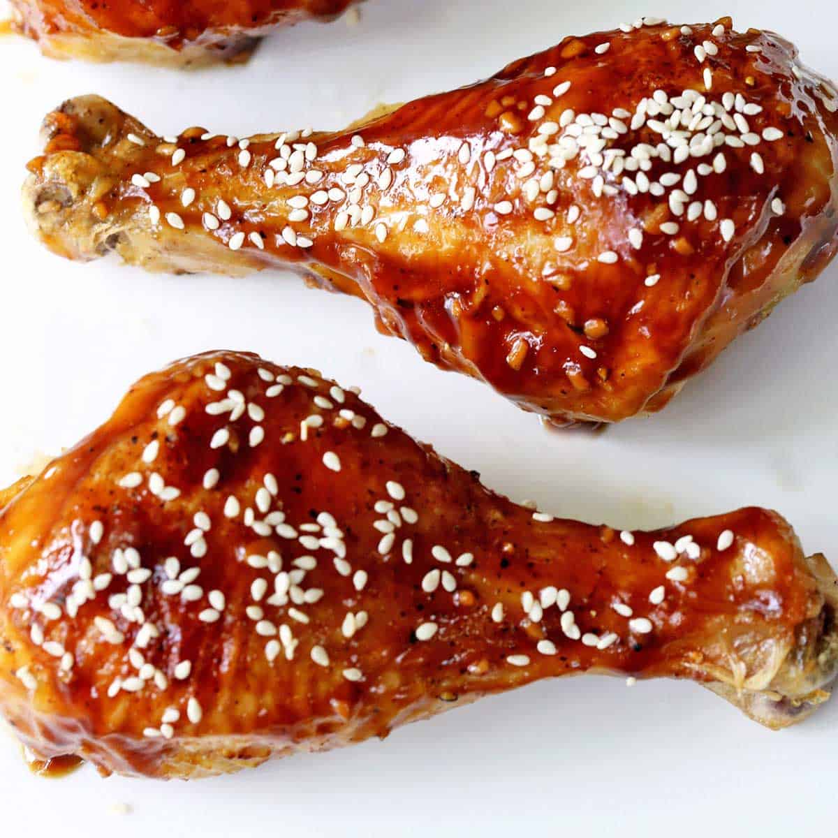 Teriyaki chicken drumsticks are topped with sesame seeds.