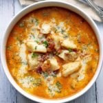 Keto fish chowder is served in a white bowl with spoons.