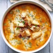 Keto fish chowder is served in a white bowl with spoons.