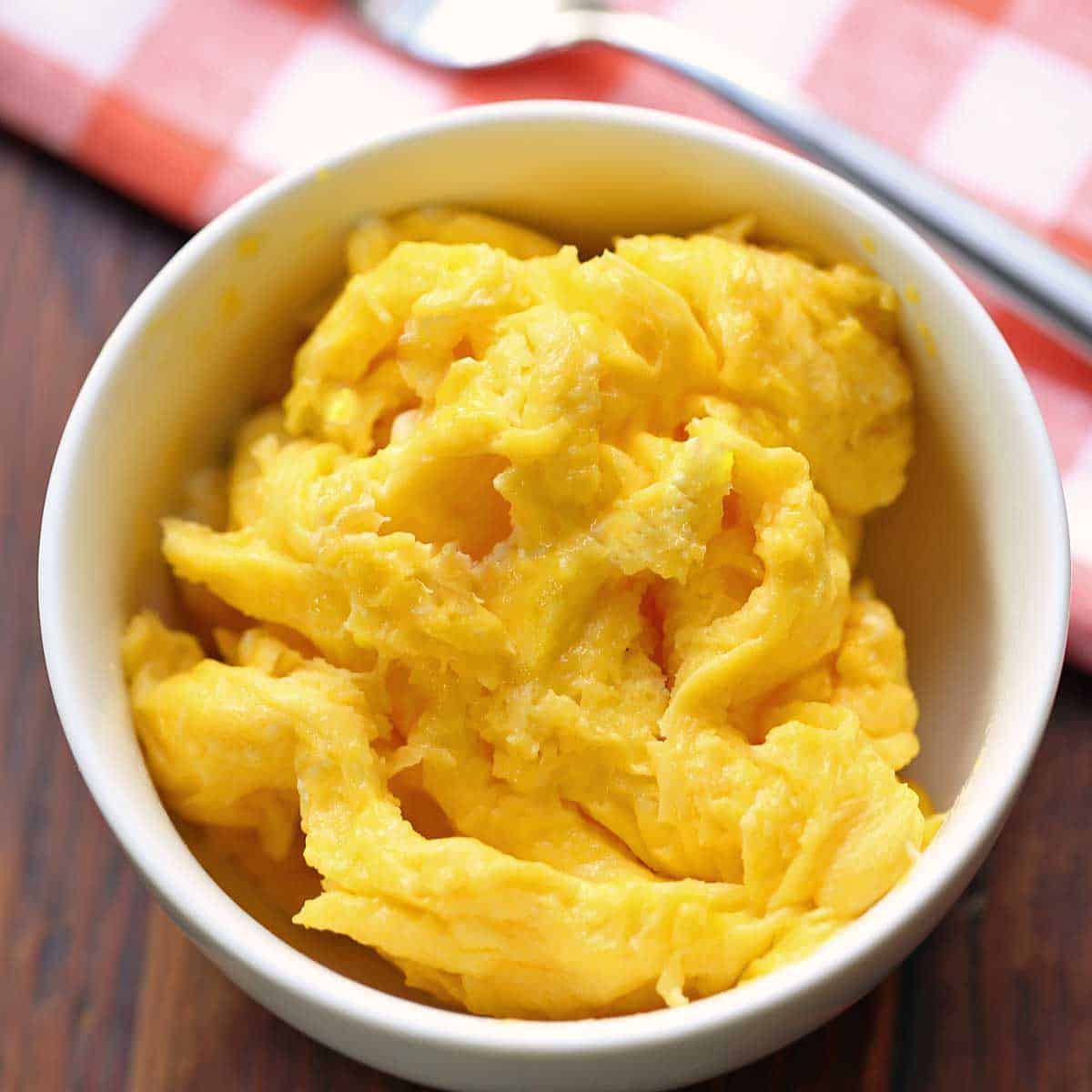 Microwave scrambled eggs are served in a white bowl.