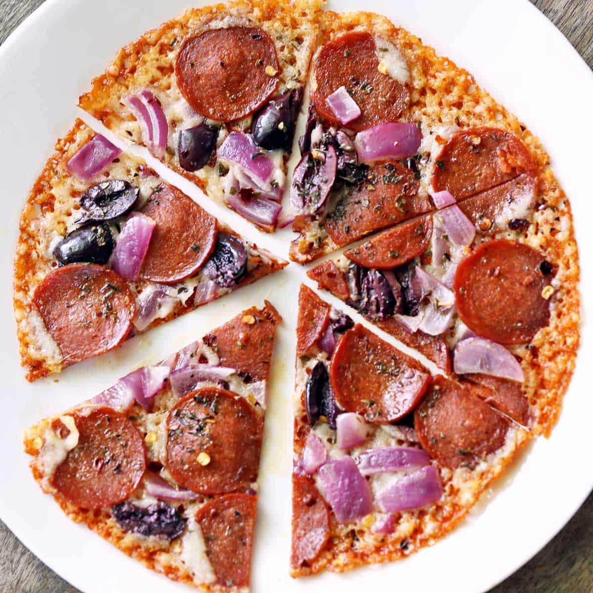 Crustless pizza is served on a white plate.
