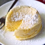 Microwave cheesecake is served on a white plate with a fork.