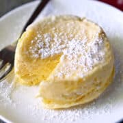 Microwave cheesecake is served on a white plate with a fork.