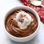 Keto chocolate mousse is topped with whipped cream.