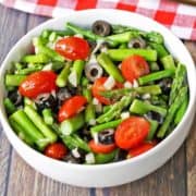 Asparagus salad is served in a white bowl with a napkin.