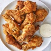 Garlic parmesan wings are served with a dipping sauce.