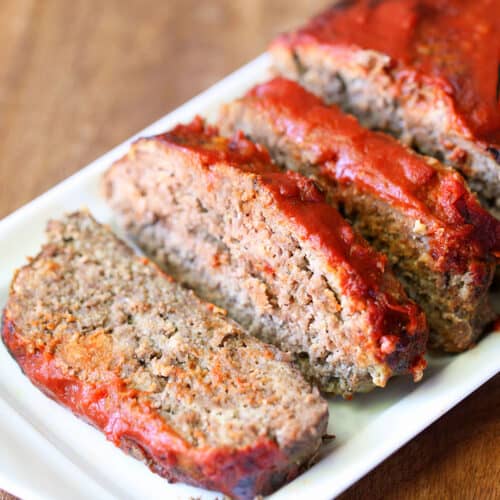 A keto meatloaf is served on a white serving tray.
