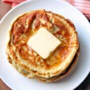 Cream cheese pancakes are topped with butter.
