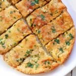 Keto garlic bread is served on a white plate.