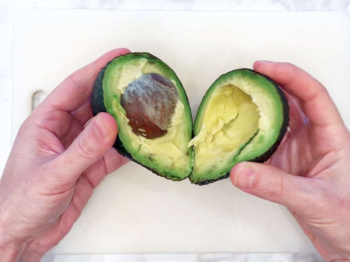 Cutting an avocado open.