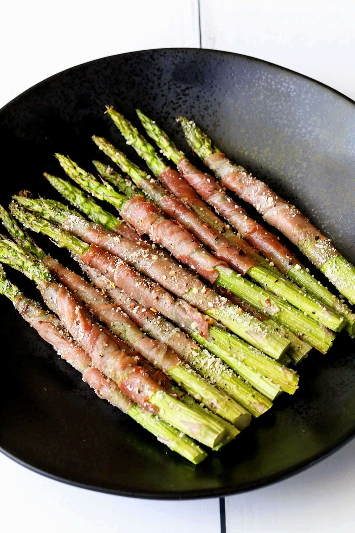 Prosciutto-Wrapped Asparagus is served on a plate.