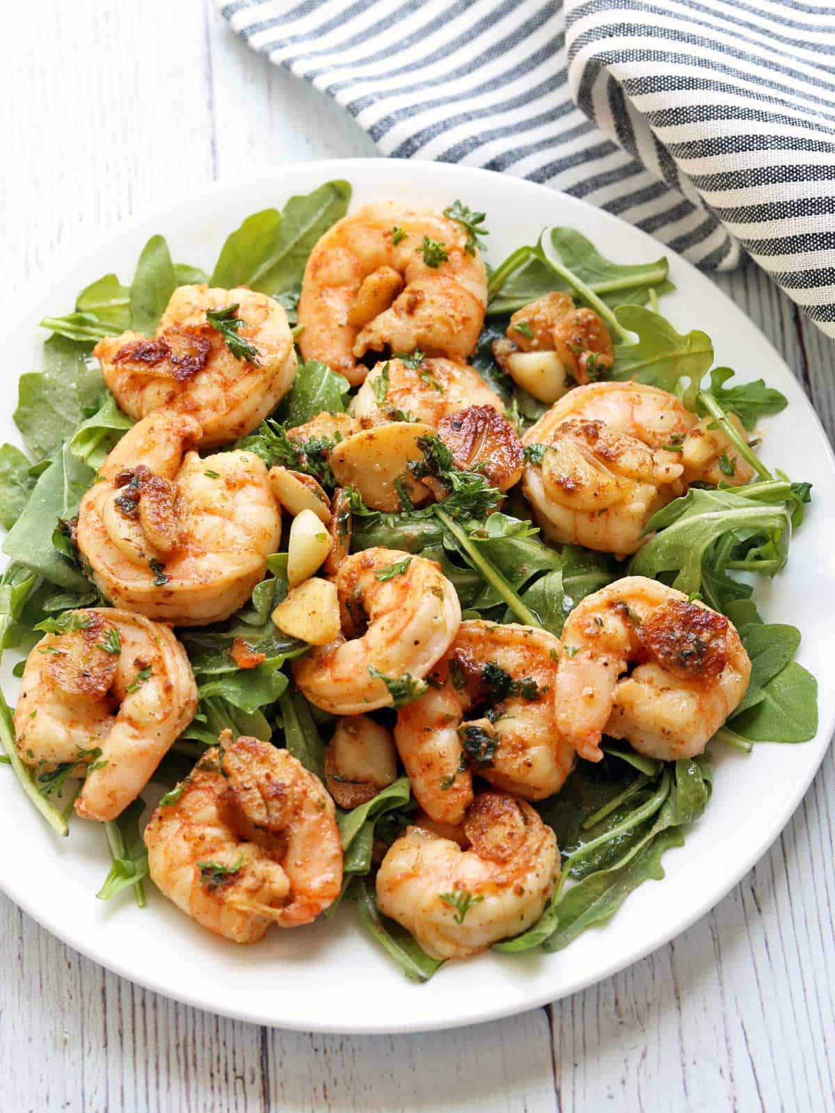 Garlic butter shrimp served over arugula leaves.
