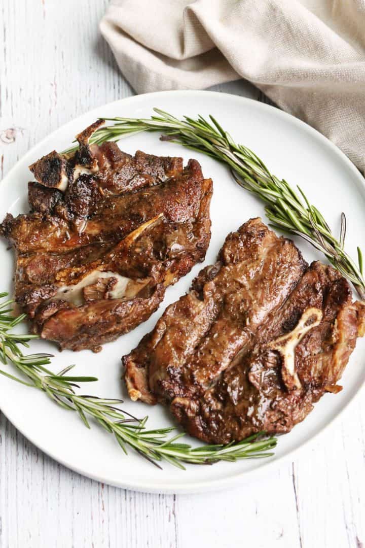 Lamb shoulder chops served on a white plate.