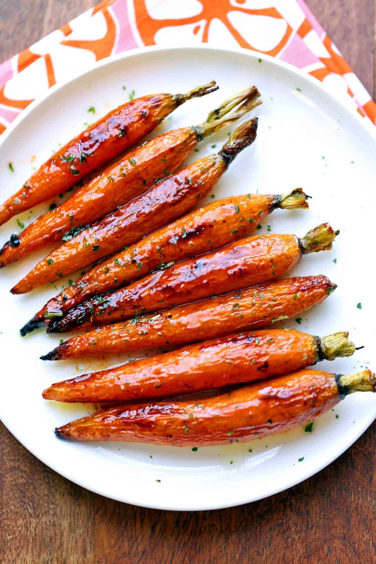 Roasted carrots are served on a white plate.