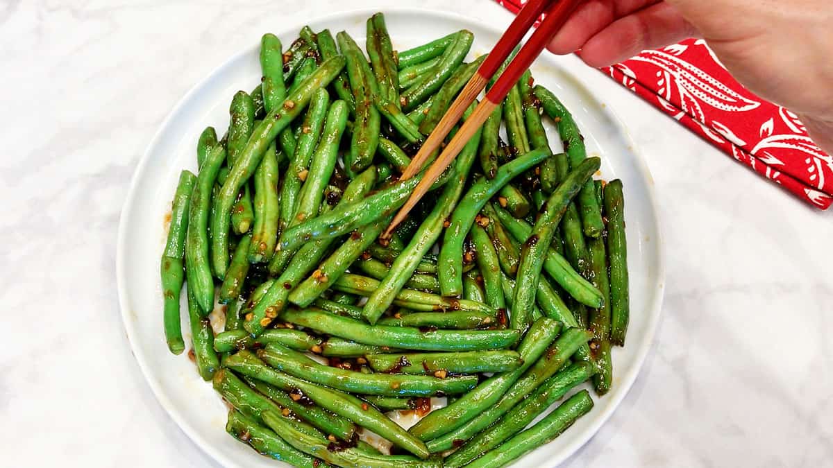 The dish is served and eaten with chopsticks.