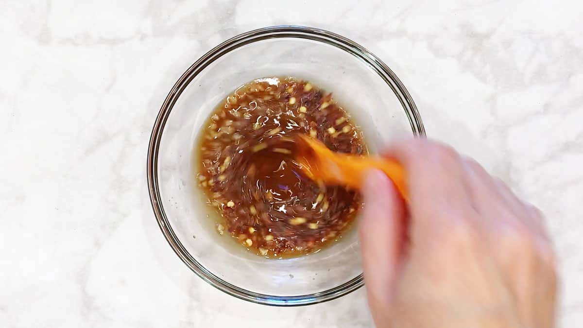 Mixing the sauce in a glass bowl.