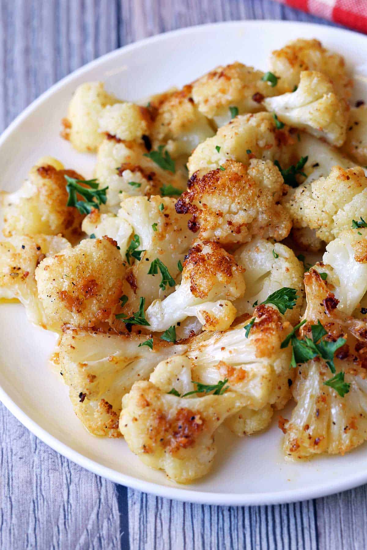 Roasted cauliflower is served on a white plate.