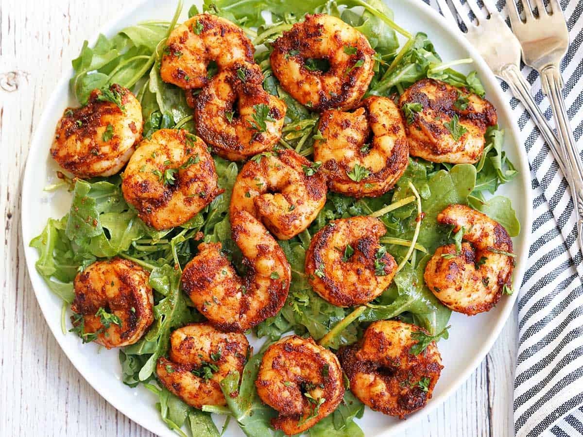 Spicy shrimp served on arugula leaves.