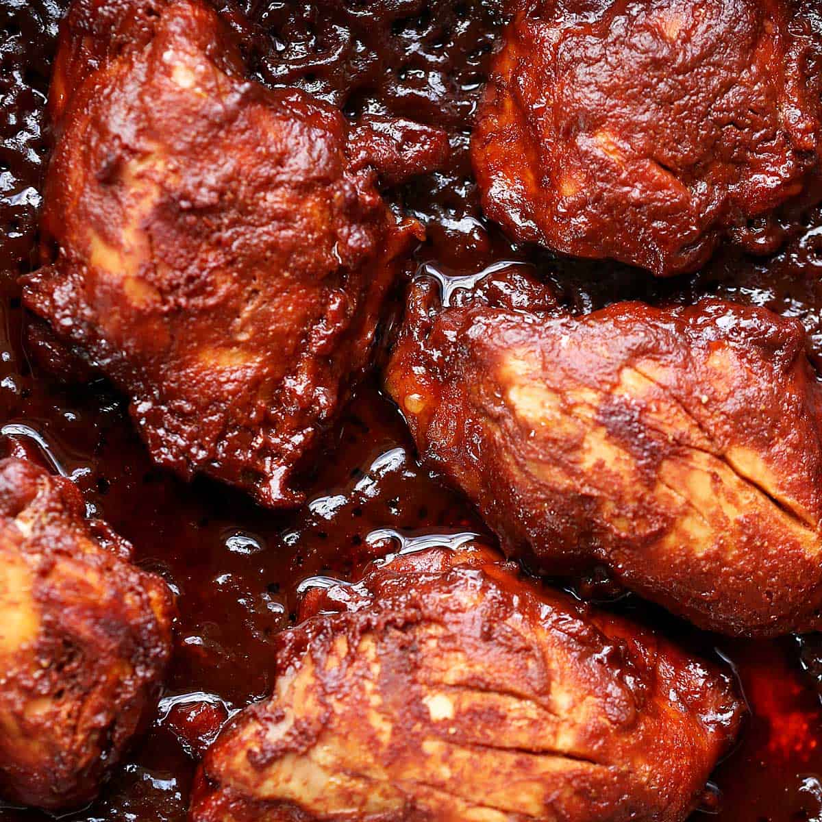 Chicken thighs covered in bbq sauce.