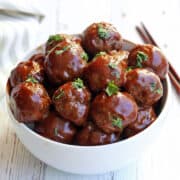 Sweet and sour meatballs are served with chopsticks.