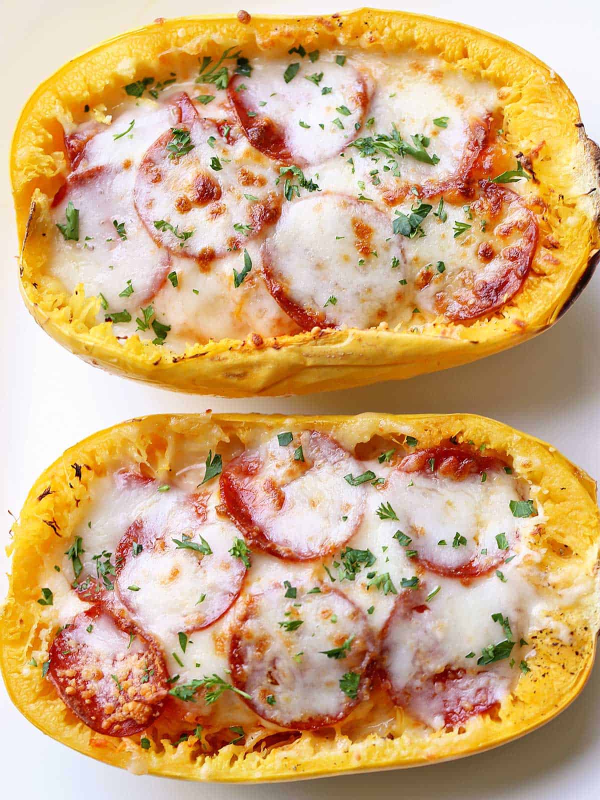 Spaghetti squash pizza is served on a white plate. 
