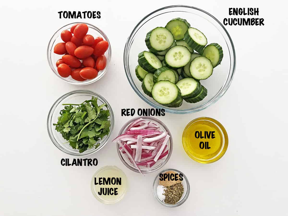 The ingredients needed to make a cucumber tomato salad.