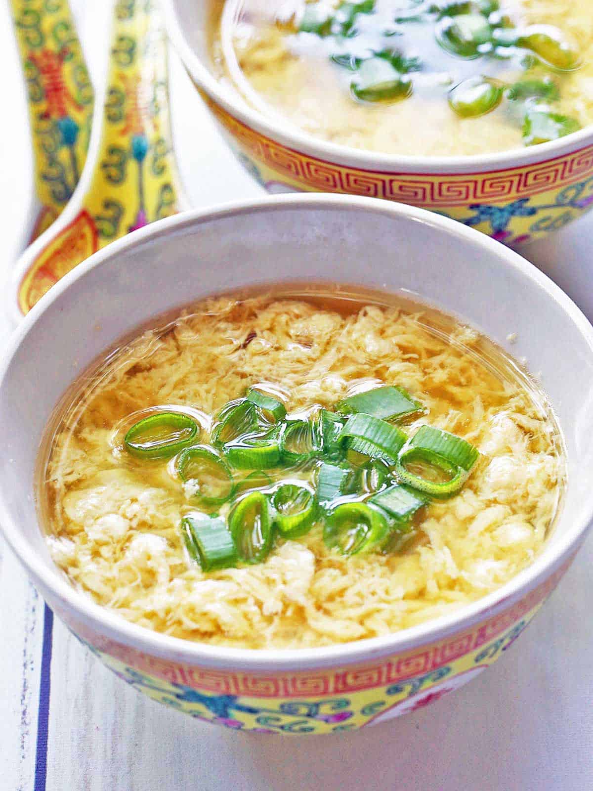 Egg drop soup is served in a Chinese soup bowl. 