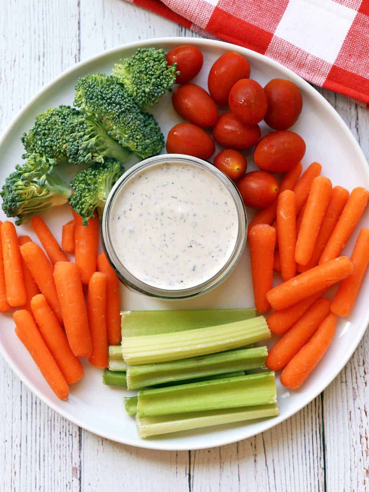 Ranch dressing is served with vegetables. 