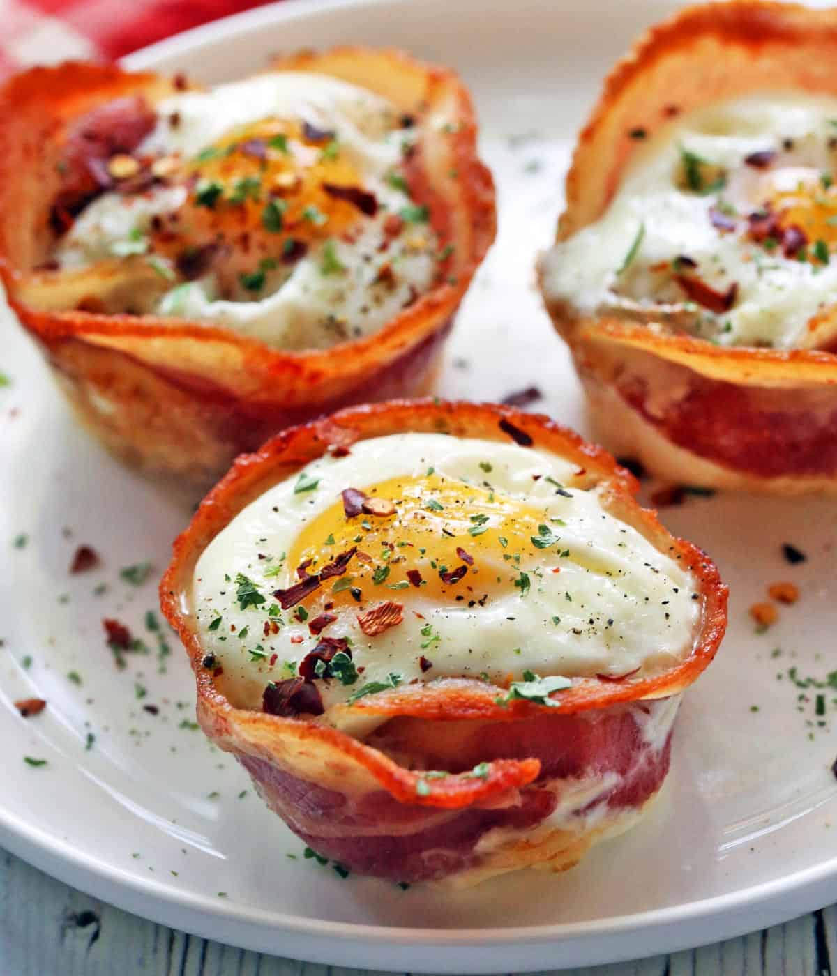 Bacon egg muffins served on a white plate.