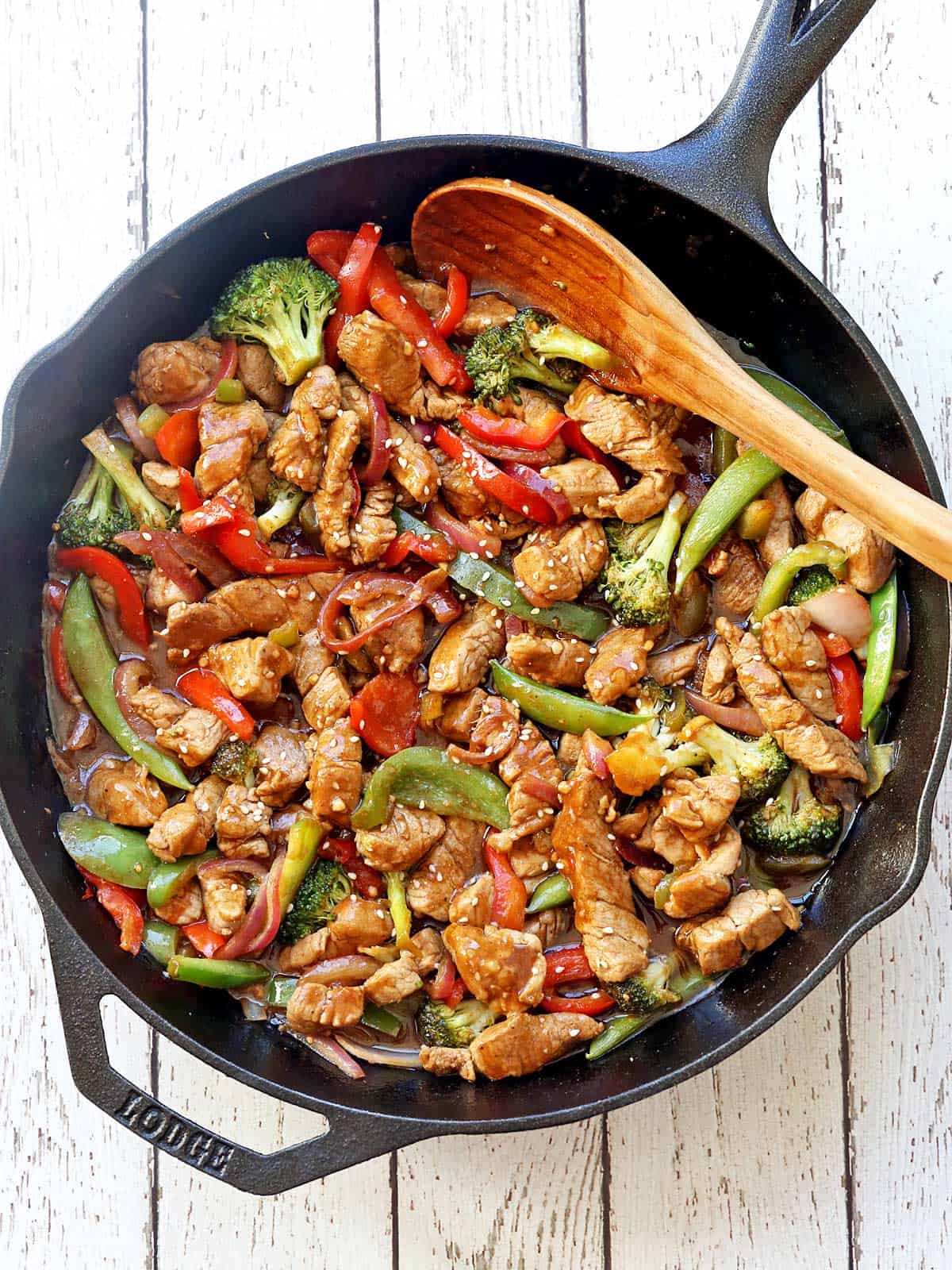 Pork stir fry in a cast-iron skillet.
