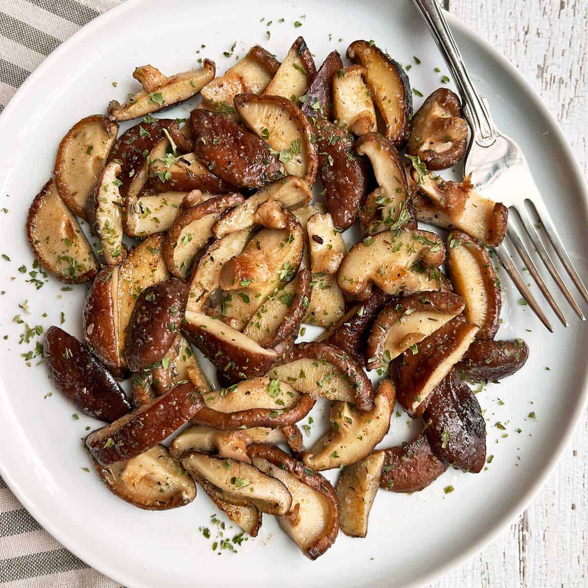 The mushrooms are served on a white plate.