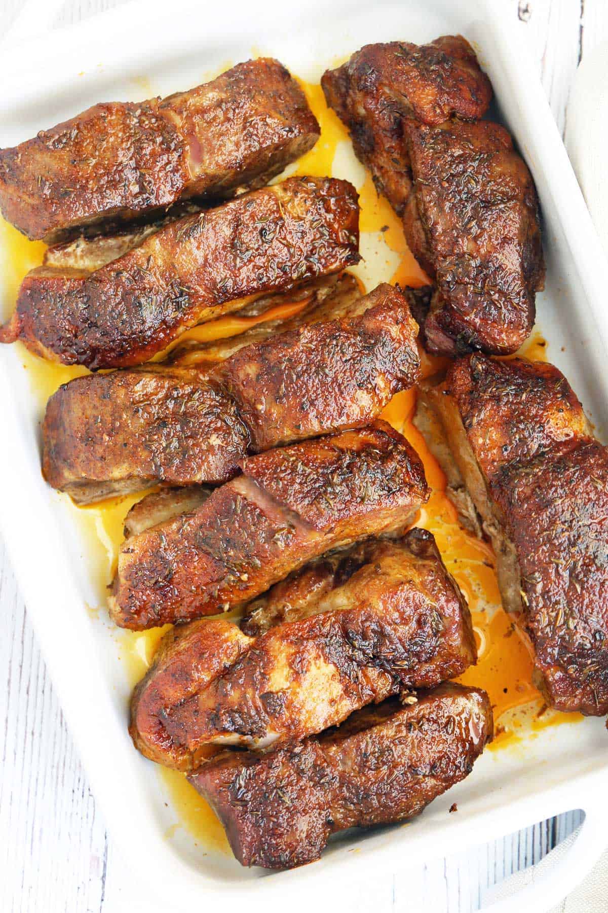 Country style ribs are served in a white dish.