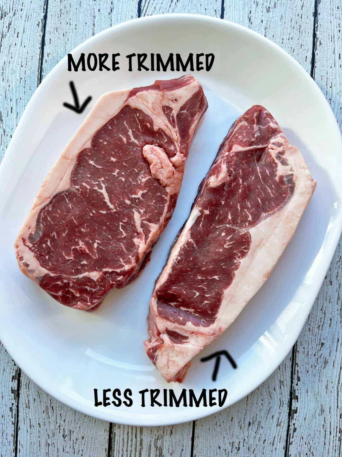 Two New York steaks with different levels of trimming.