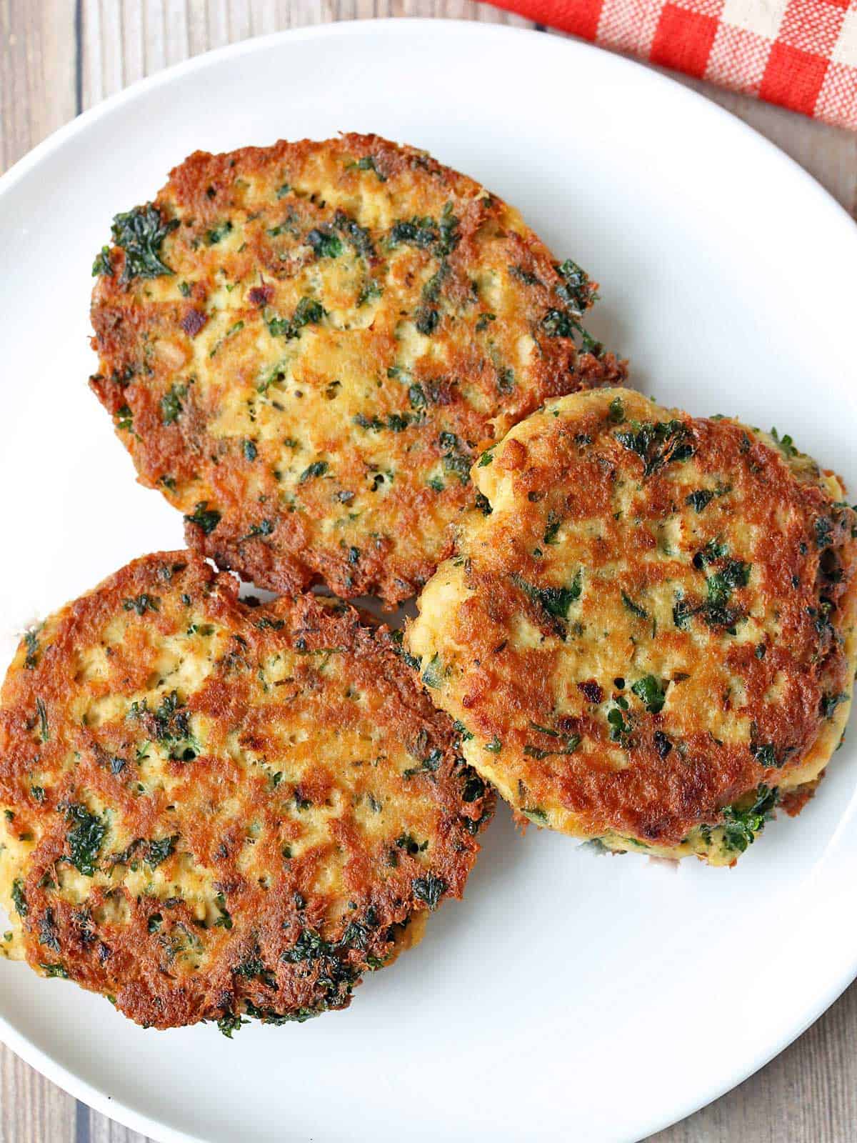 Three salmon cakes are served on a white plate.