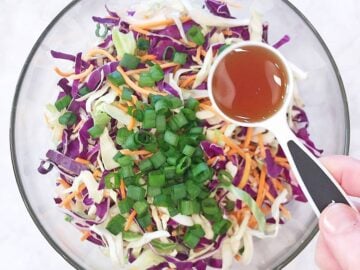 Adding sesame oil to the salad.