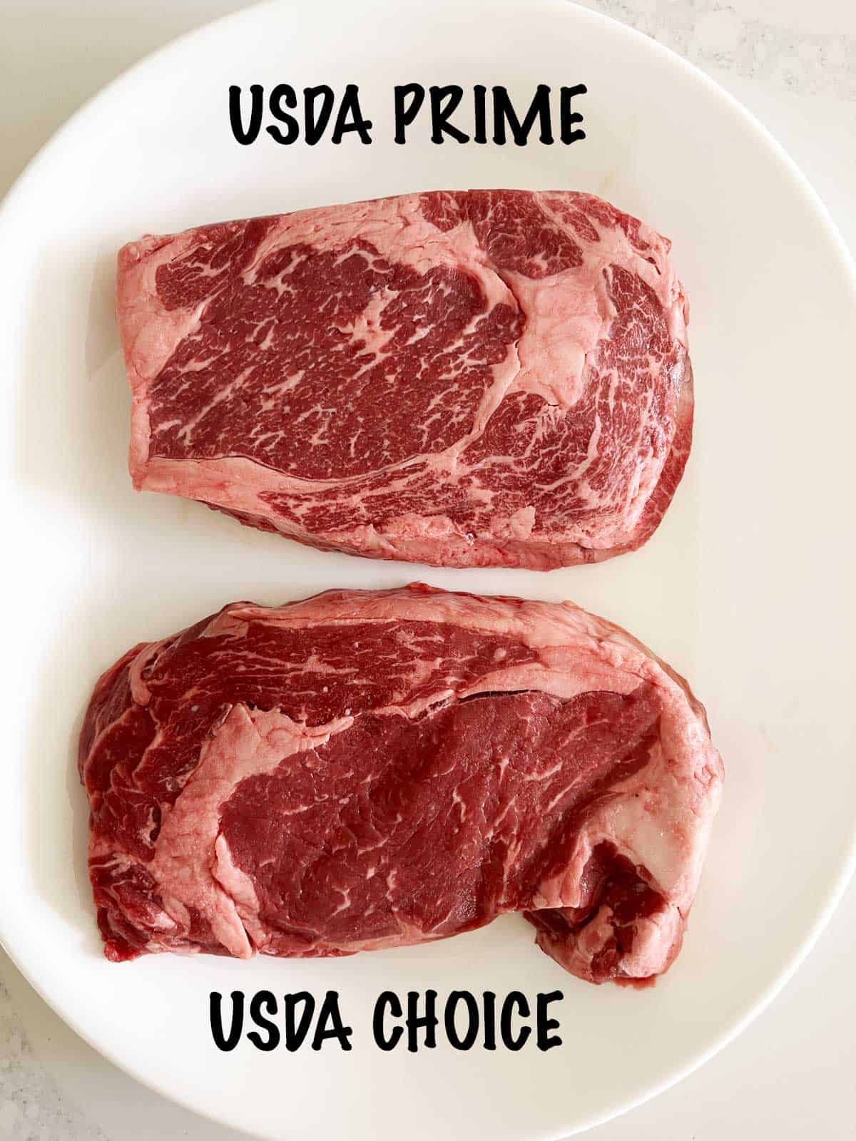 Prime-grade and a choice-grade ribeye steaks on a plate.
