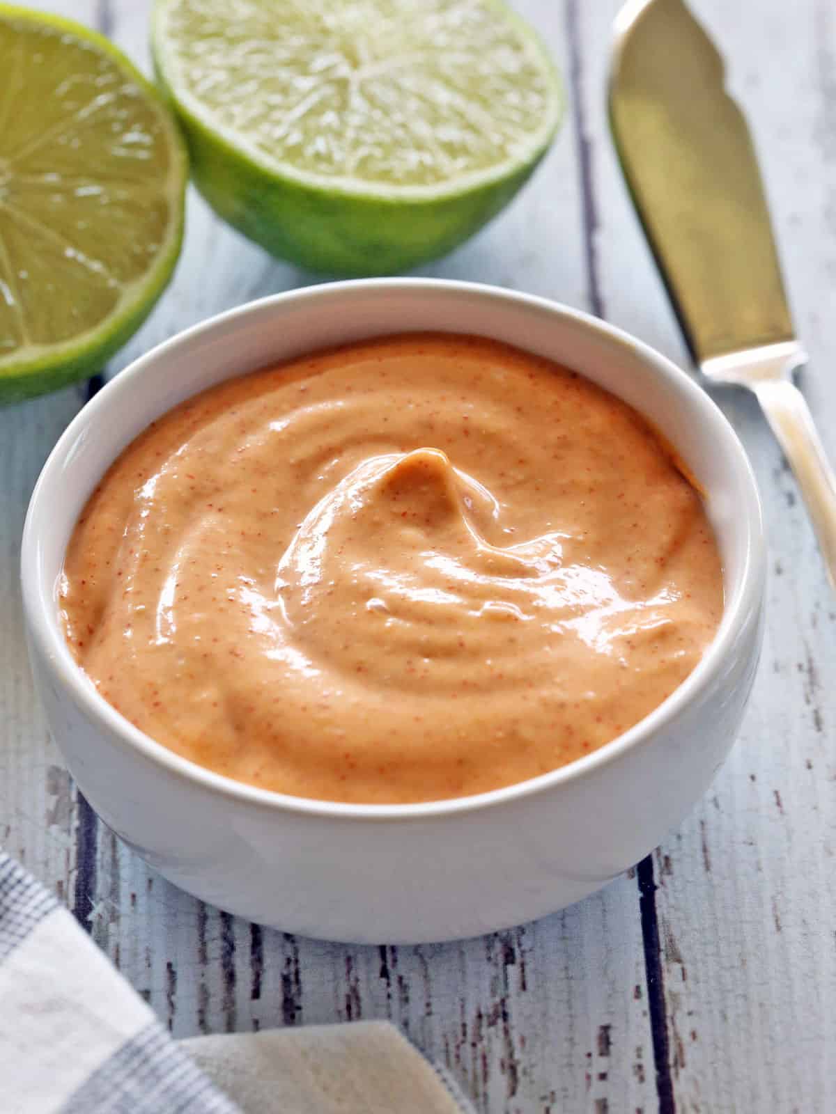 Sriracha mayo is served in a white bowl. 