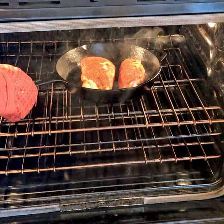 Placing blackened chicken in the oven.