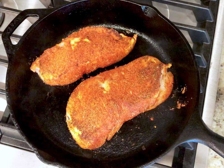 Blackened chicken in skillet.