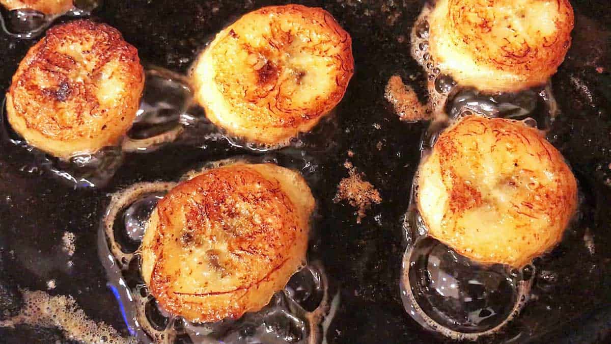 Fried banana slices in a skillet.