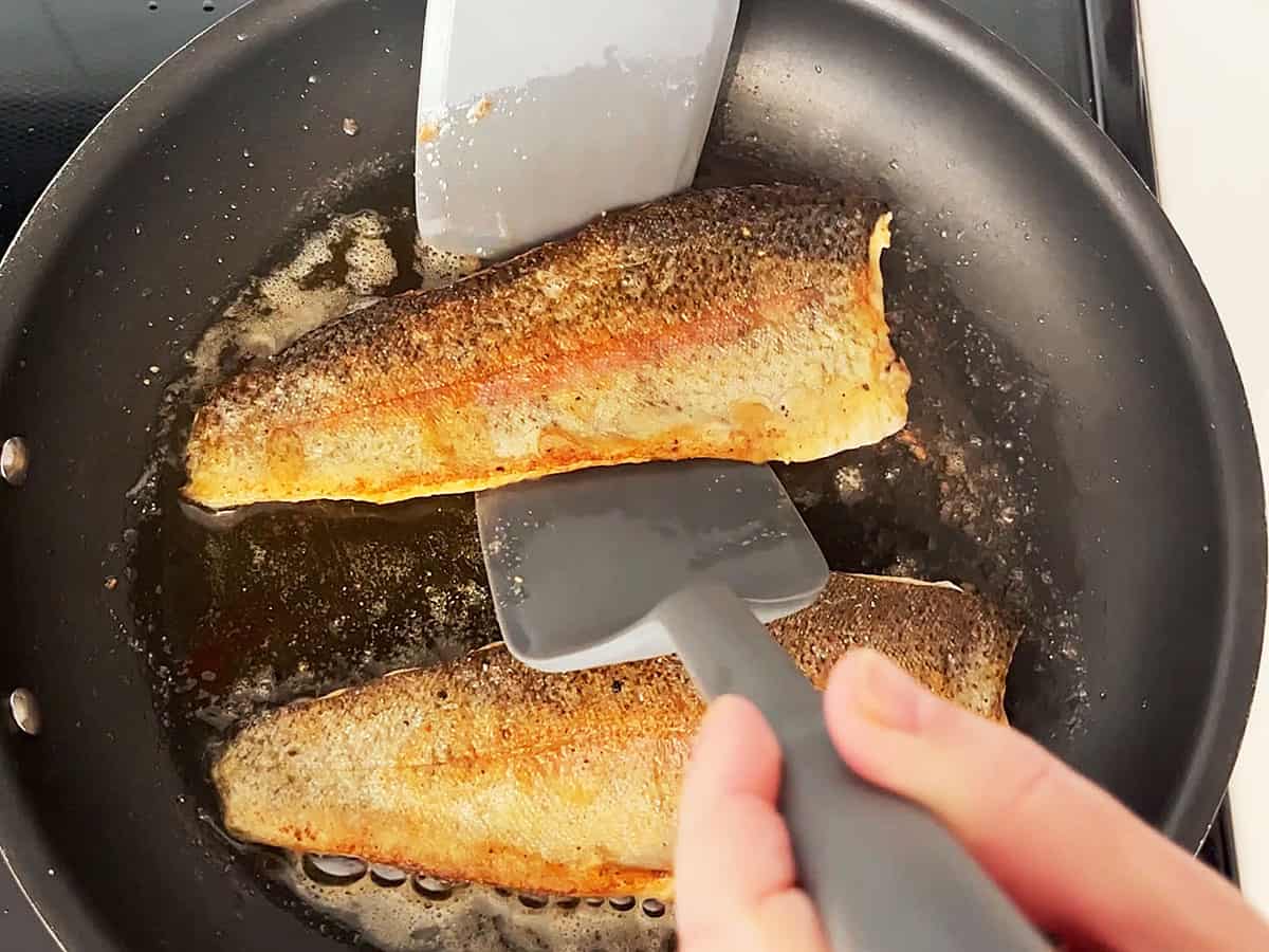Flipping rainbow trout in the skillet.