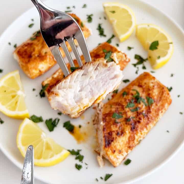 Serving grilled mahi mahi with lemon slices.