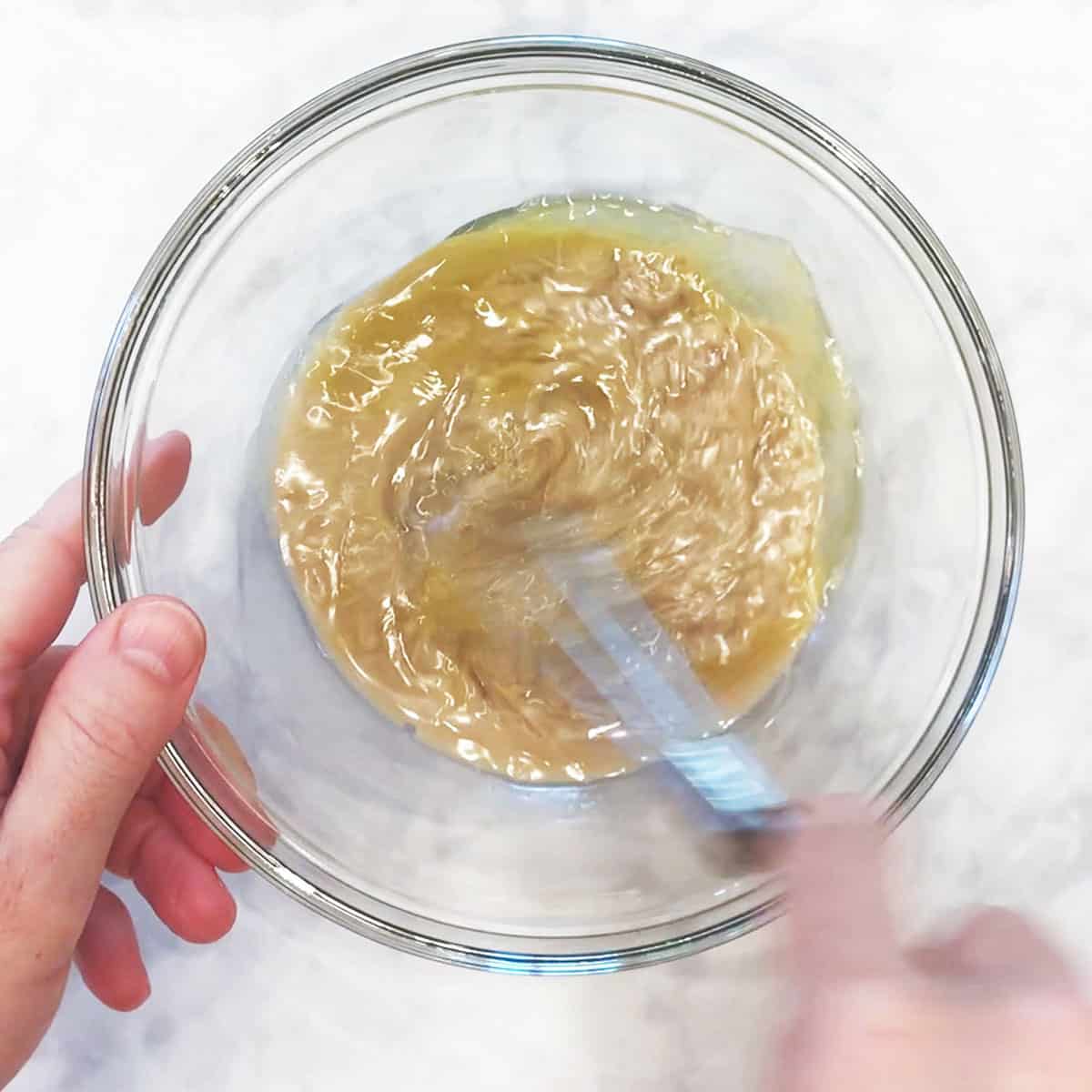 Mixing the tahini sauce ingredients in a bowl.