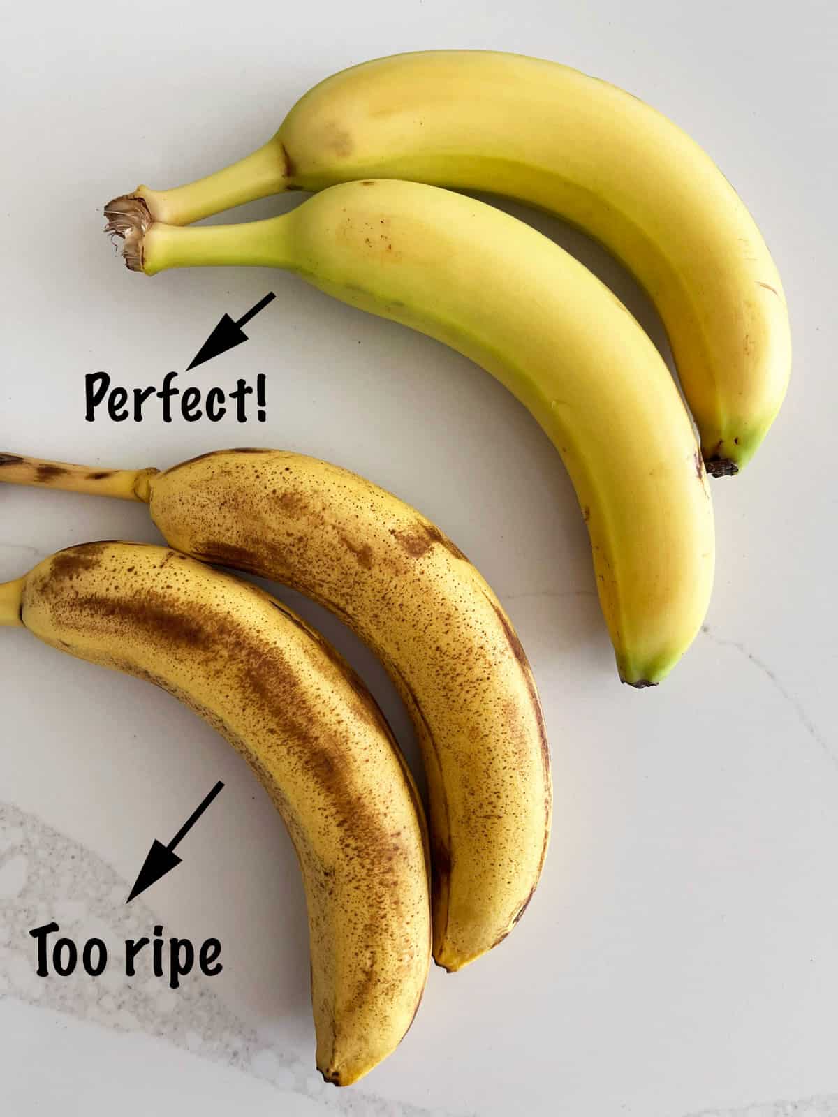 Two bananas that are too ripe to fry and two that are perfect for frying.